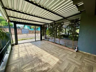 Área externa coberta com piso de cerâmica e vista para o quintal.