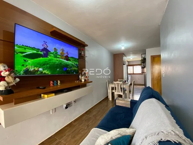 Sala de estar com televisão e sofá em um imóvel no Brasil.