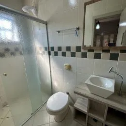 Banheiro com revestimento de azulejos brancos e escuros.