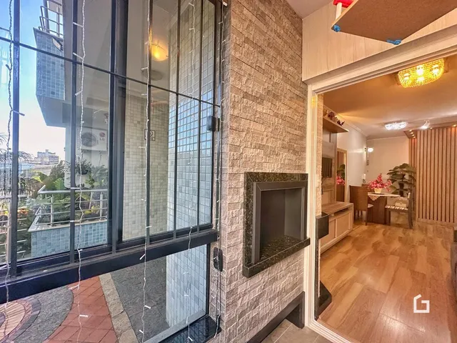Vista interna de um apartamento com parede de pedra e porta de vidro.