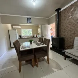 Foto de um ambiente interno com mesa de jantar e cadeiras.
