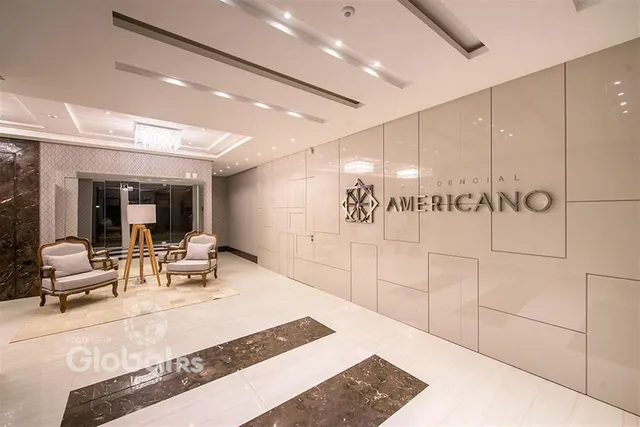 Corredor interno de um imóvel residencial com acabamentos modernos e piso em mármore.