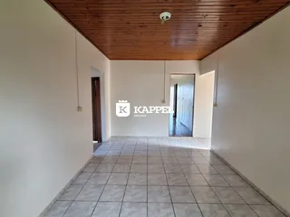 Hall de entrada com piso de cerâmica e teto de madeira.