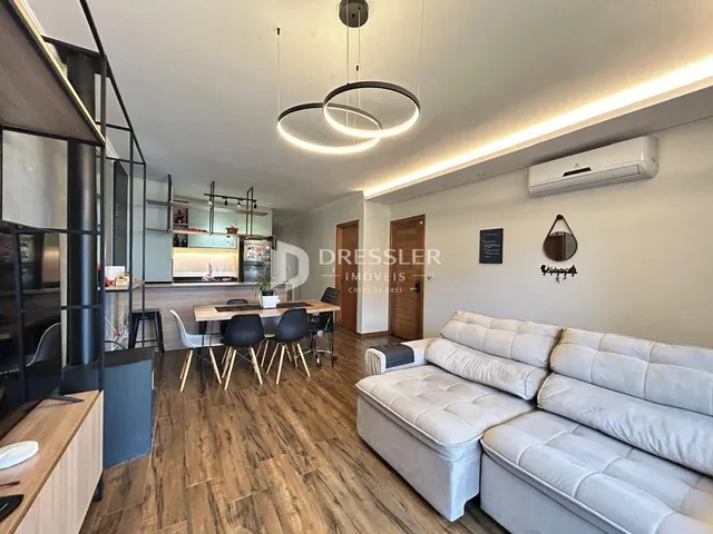 Sala de estar com sofá e mesa de jantar em um apartamento.