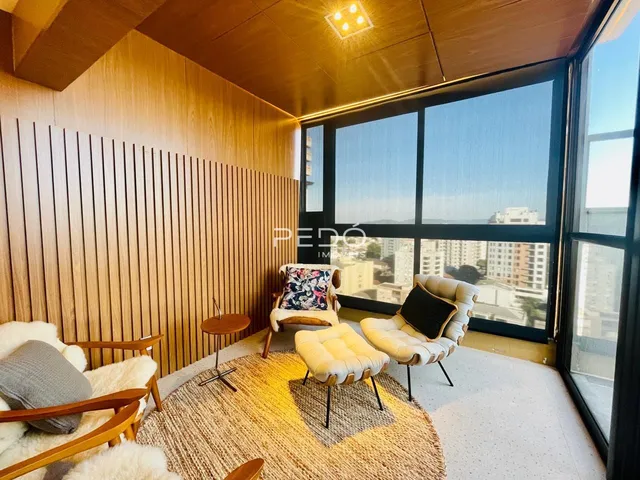 Sala de estar com grandes janelas e decoração moderna em Lajeado.