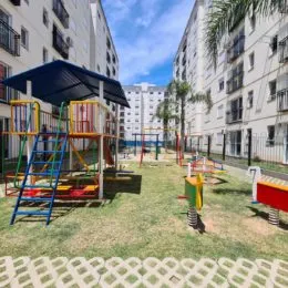 Foto de uma área externa com gramado e equipamentos de playground.