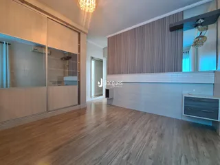 Sala de estar com piso de madeira clara e paredes brancas.