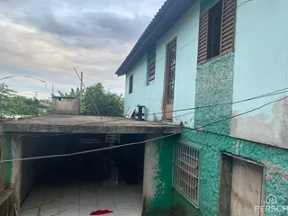 Fachada externa de uma residência com paredes azuis claras e cobertura de metal.