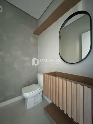 Foto de um banheiro com revestimento de madeira e espelho.