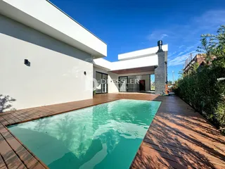 Fachada de casa com piscina e deck de madeira no Brasil.