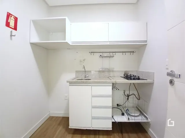 Foto de uma cozinha com armários brancos e bancada clara.