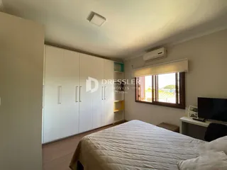 Quarto com armários brancos e piso de madeira.