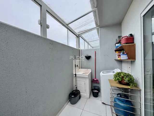 Um corredor interno com teto de vidro e paredes brancas.