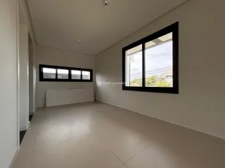 Ambiente interno de uma sala com piso claro e janela grande.