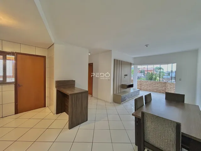 Ambiente interno de uma sala de estar com área de jantar em uma residência.