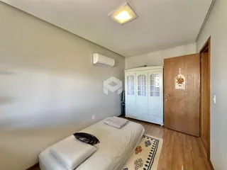 Quarto com cama e guarda-roupa em ambiente claro.