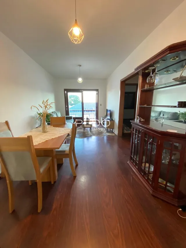 Sala de jantar com piso de madeira e armário de madeira.