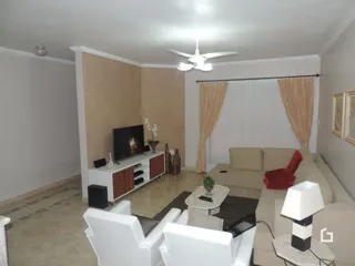 Sala de estar com sofá e televisão em ambiente interno.