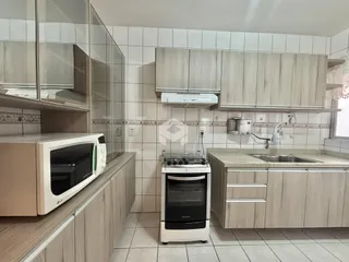 Foto de uma cozinha com armários e revestimento cerâmico.