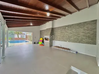 Vista ampla de um ambiente interno com acesso a uma área externa e piscina.