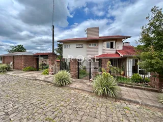 Fachada de uma casa em Lajeado, Brasil, com muro de tijolos e cerca de ferro.