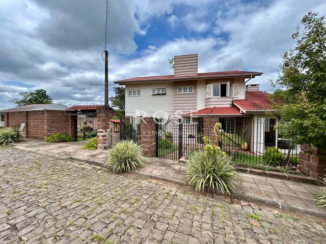 Fachada de uma casa em Lajeado, Brasil, com muro de tijolos e cerca de ferro.