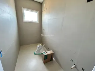 Hall de entrada com paredes claras e piso liso.