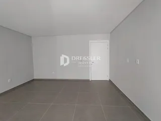 Interior de um cômodo com paredes brancas e piso de cerâmica.