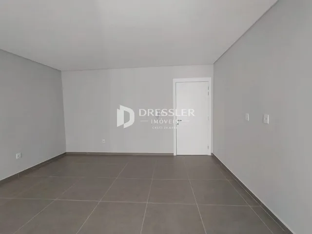 Interior de um cômodo com paredes brancas e piso de cerâmica.