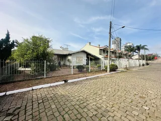 Vista da fachada de uma residência em Lajeado, Brasil, com cerca e calçada de paralelepípedos.