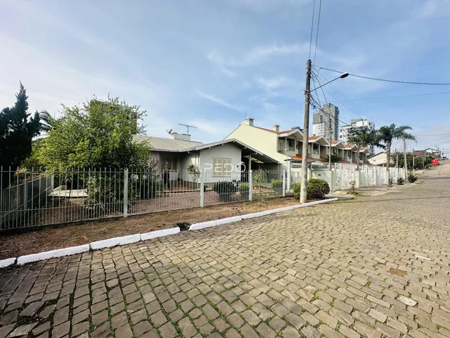 Vista da fachada de uma residência em Lajeado, Brasil, com cerca e calçada de paralelepípedos.