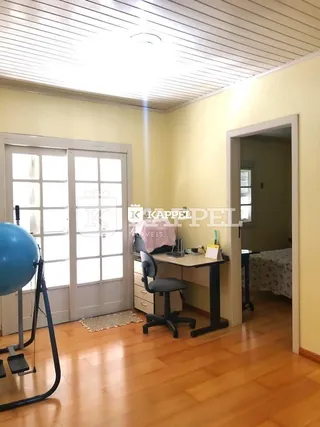 Ambiente interno com piso de madeira e porta de vidro.