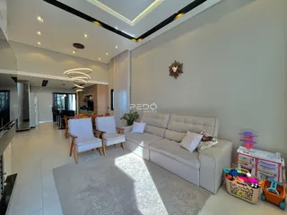 Sala de estar moderna com sofá e cadeiras em um ambiente claro.