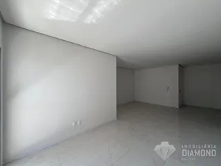 Ambiente interno de uma sala ampla e clara com piso de porcelanato.