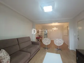 Sala de estar com sofá e piso de madeira clara.