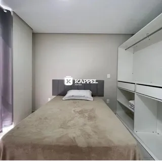 Foto de um quarto com cama grande e cabeceira escura.