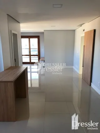 Hall de entrada com paredes brancas e piso claro.
