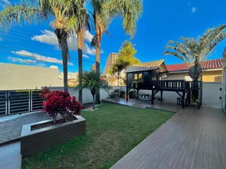 Fachada de uma residência em Lajeado, Brasil, com jardim e deck de madeira.
