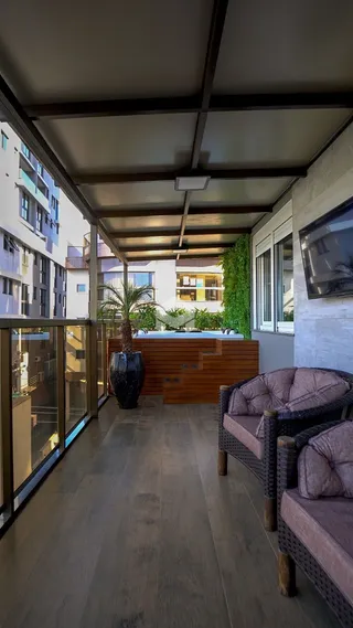 Varanda com piso de madeira e mobiliário de exterior.