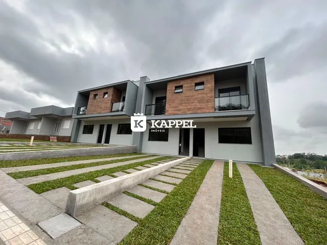 Fachada de um prédio residencial moderno com jardim e calçadas em Lajeado, Brasil.