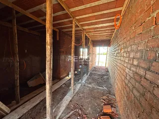 Imagem de uma estrutura interna em construção com vigas de madeira expostas.