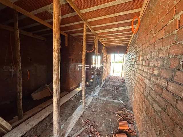 Imagem de uma estrutura interna em construção com vigas de madeira expostas.