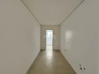 Corredor interno de uma residência com paredes brancas e piso claro.