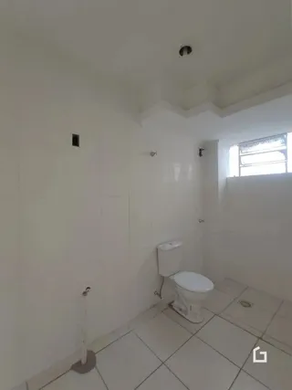 Foto de um banheiro interno com piso de cerâmica e paredes brancas.