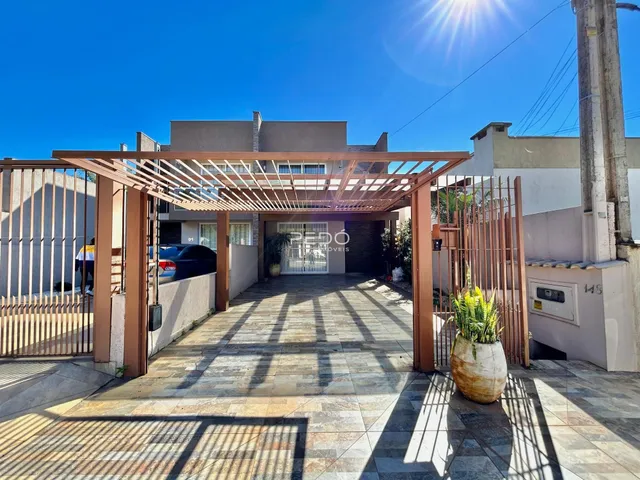 Fachada de uma residência com portão e estrutura de madeira na entrada.
