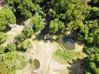 Vista aérea de uma propriedade com áreas verdes e corpos d'água.