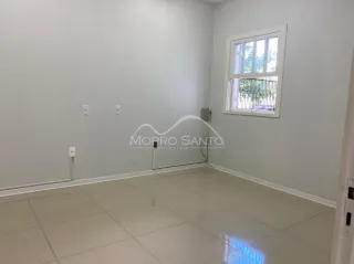 Ambiente interno de uma sala com paredes brancas e piso claro.