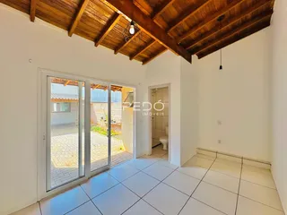 Sala de estar com portas de vidro que dão acesso a uma área externa pavimentada.