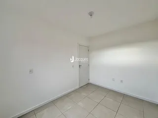 Interior de um ambiente com paredes brancas e piso de cerâmica clara.