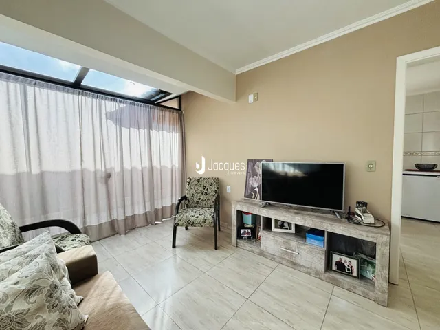 Sala de estar com grande janela e piso de cerâmica.